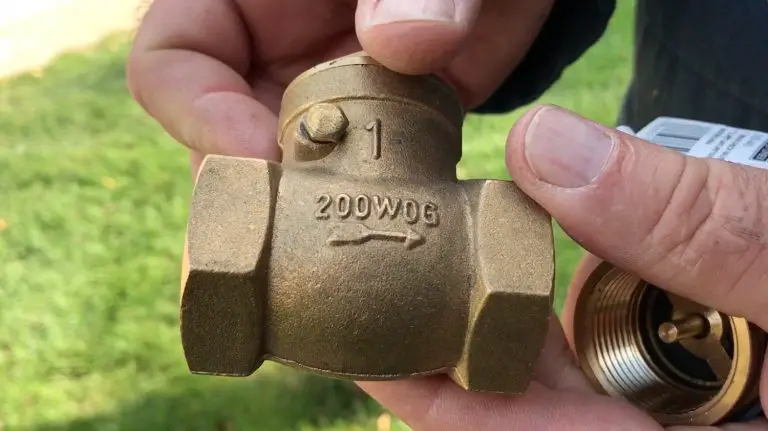 Bronze valve labeled 200WOG held by hands.