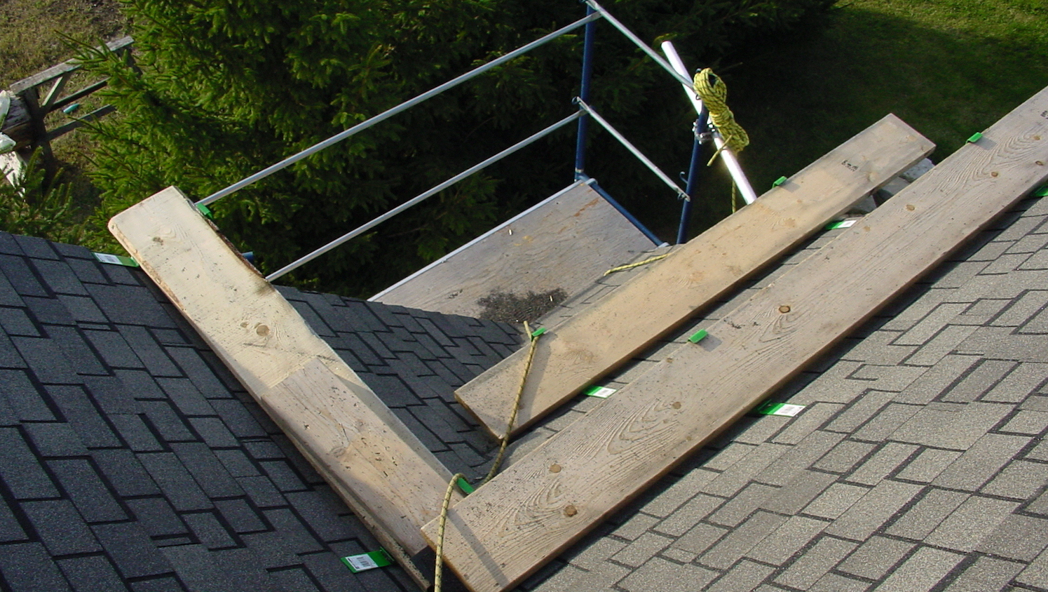 Roof shingles with wooden planks and scaffolding setup.