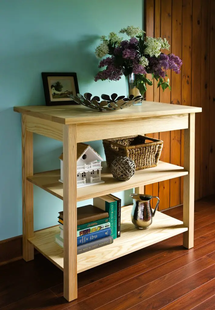 Wooden shelf with decor and flowers in vase