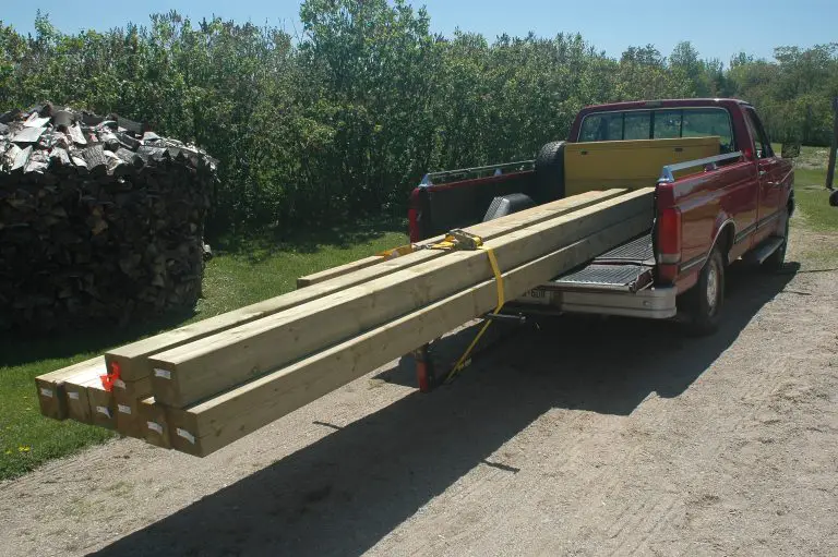 Truck carrying long wooden boards.