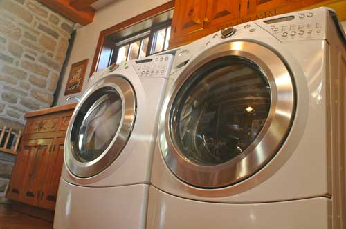 Modern front-load washing machine and dryer in laundry room.