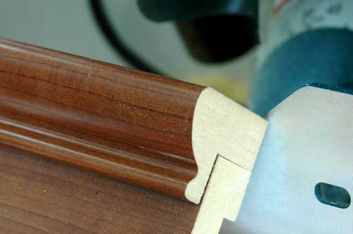 Router cutting wood moulding close-up