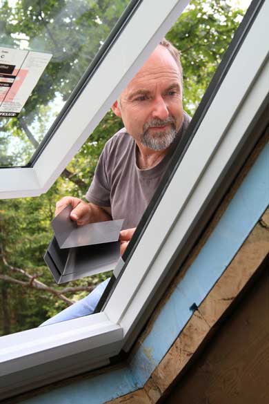 Man installing roof window frame.
