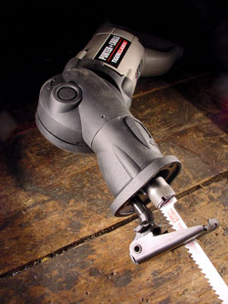 Cordless reciprocating saw on wooden table.