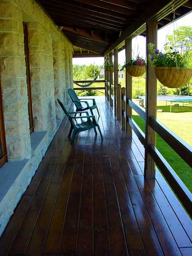 Wooden porch with chairs and hanging plants