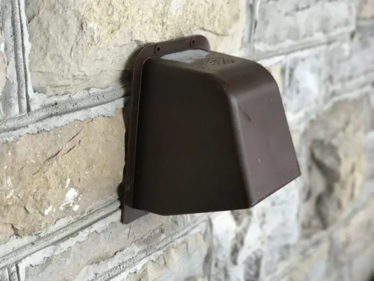Brown outdoor vent on stone wall.