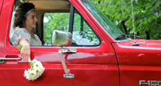 Person holding flowers in a red truck.