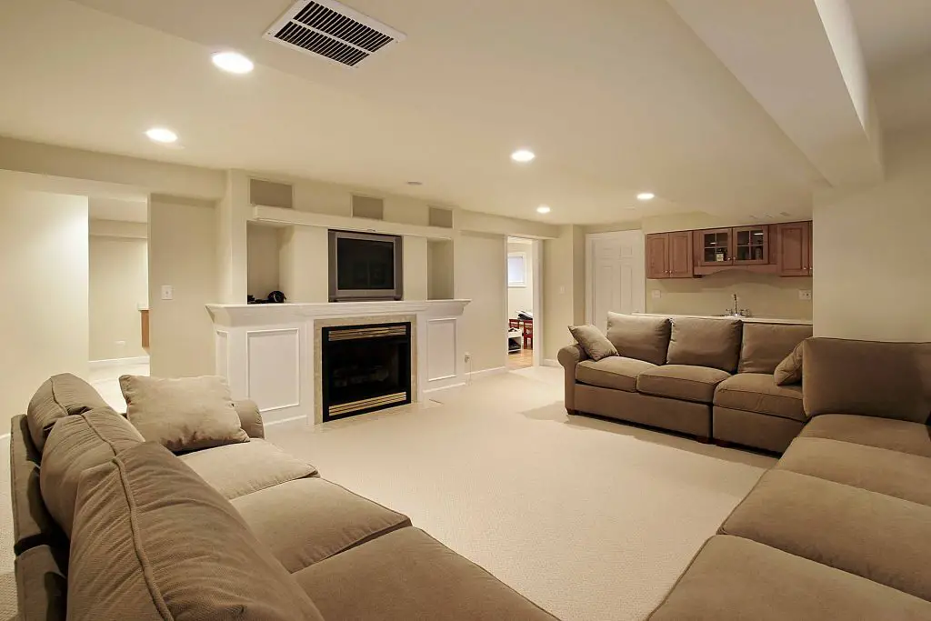 Spacious basement with sofas and fireplace.
