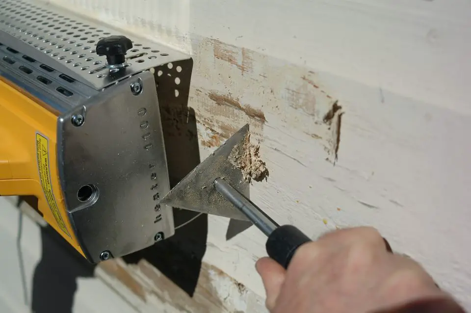 The infrared heat lamp (left) softens old paint without chemicals. A good, sharp scraper makes it much easier to remove the soft paint than the standard putty knife.