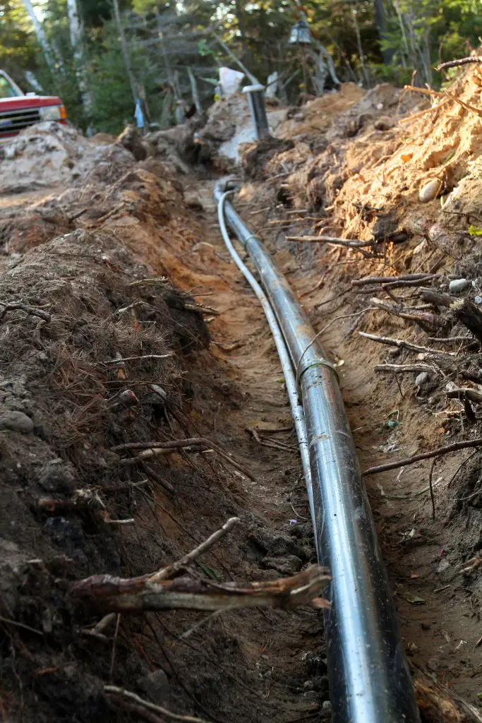 Buried pipeline under construction in a forest area.