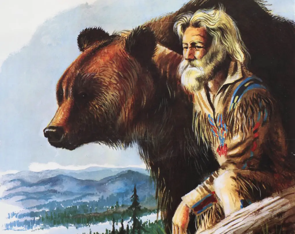 Man and bear overlooking forest landscape.
