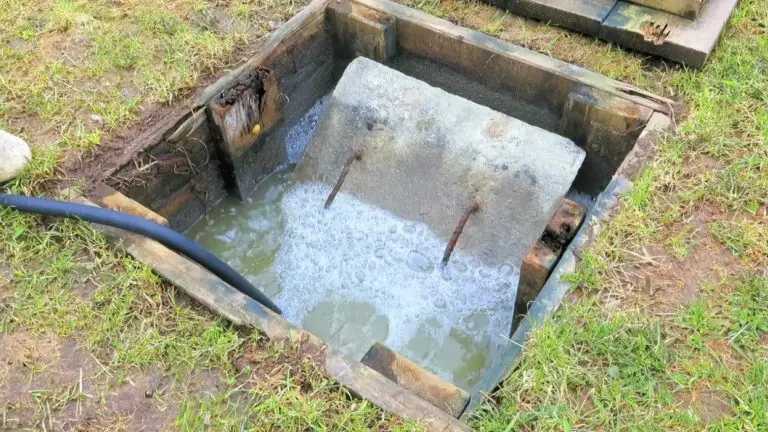 Open septic tank with concrete lid visible