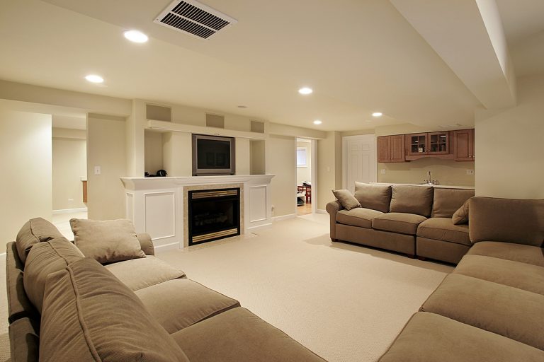 Spacious basement with cozy sofas and fireplace.