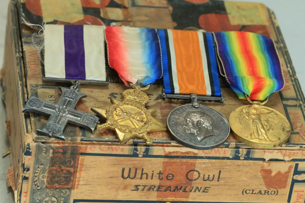 Collection of vintage military medals on cigar box.