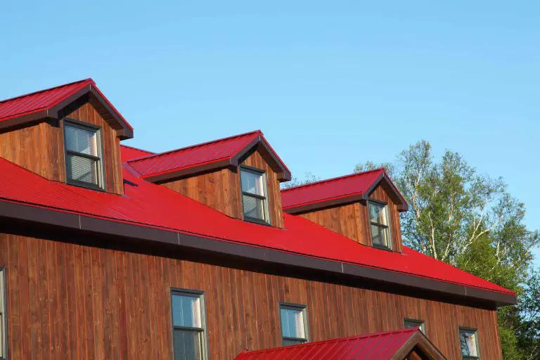 Wooden house with red metal roof.