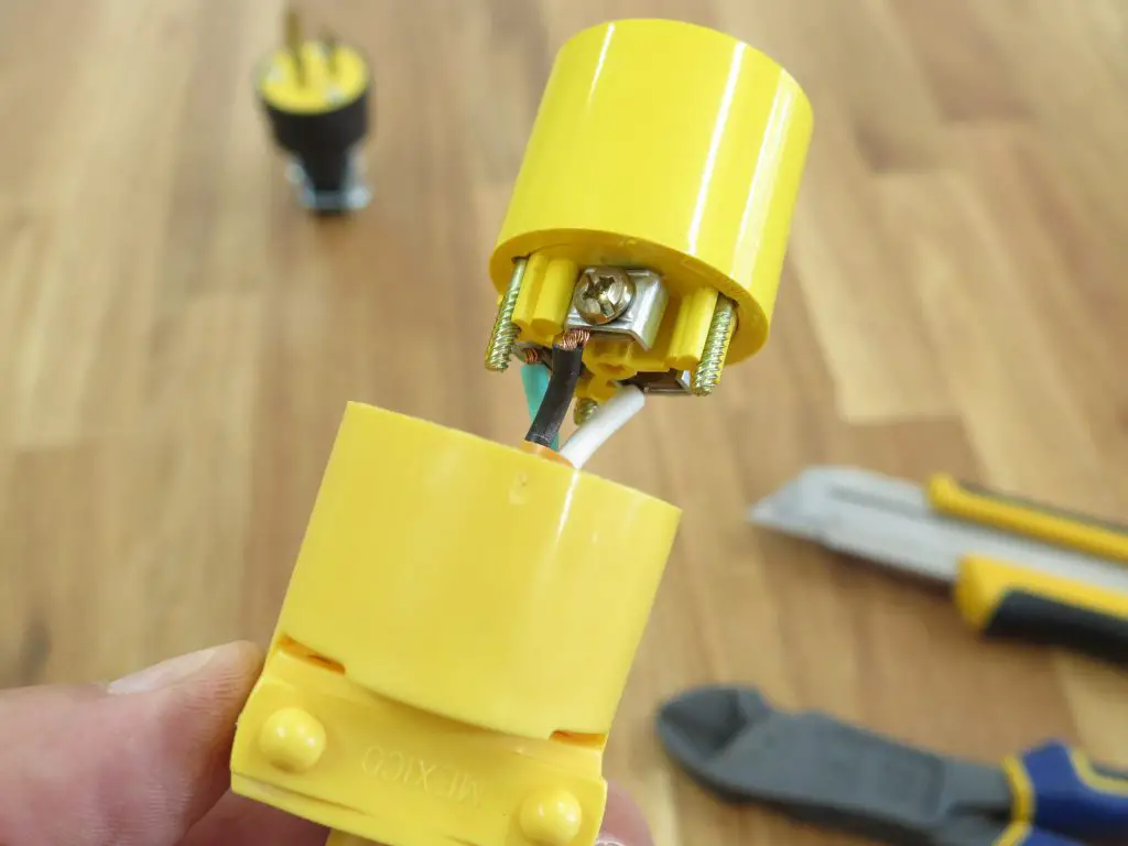 Repairing a yellow electrical plug with tools nearby.