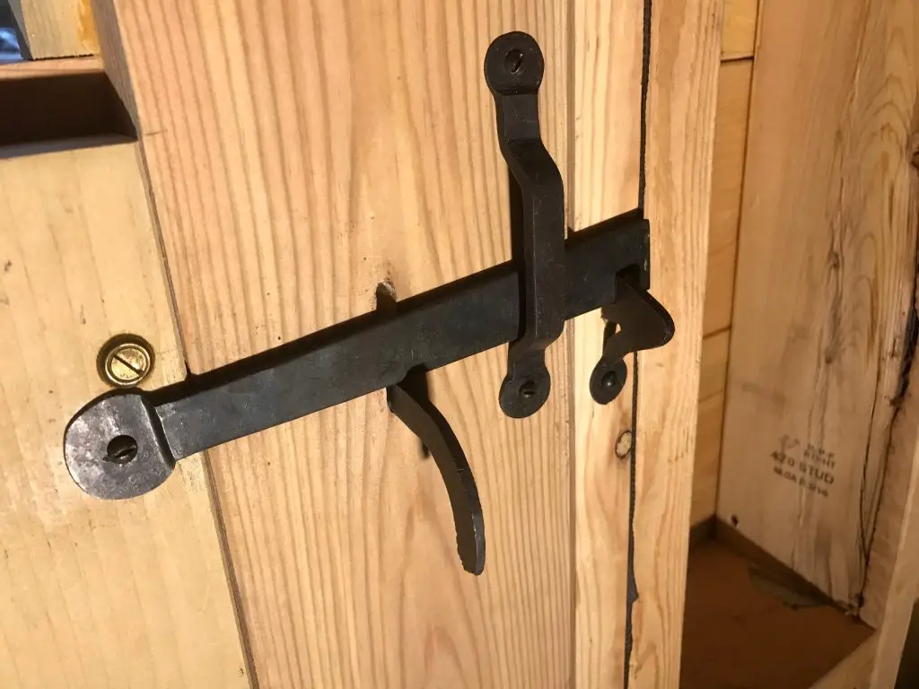 Rustic iron latch on wooden door.