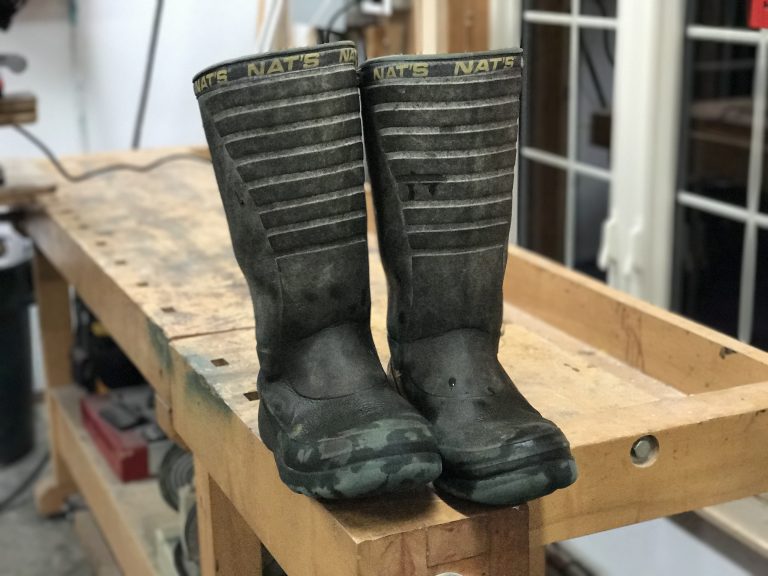 Pair of black boots on a workbench.