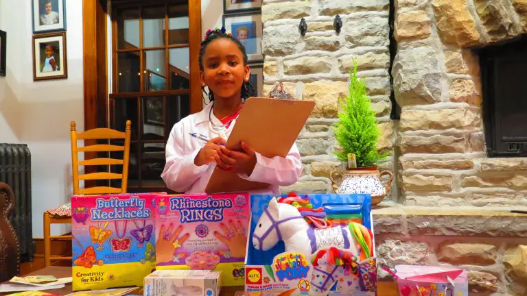 Child with clipboard and craft gifts indoors.