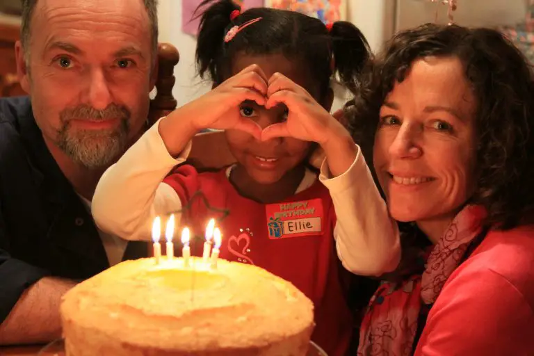 Family celebrating child's birthday with cake.