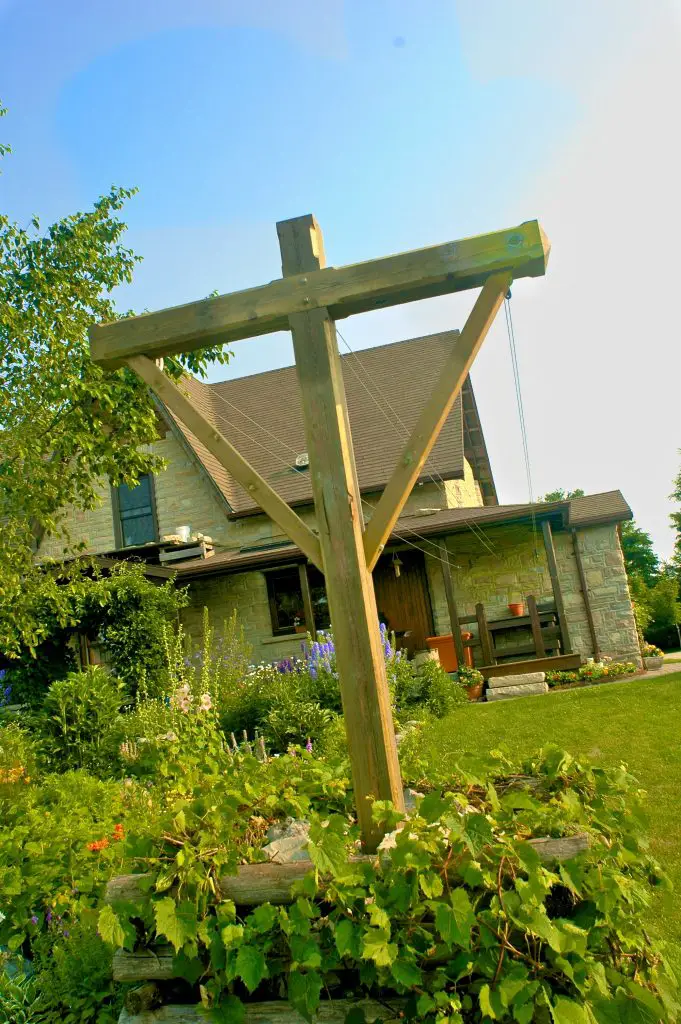 Wooden cross structure in front of house garden.