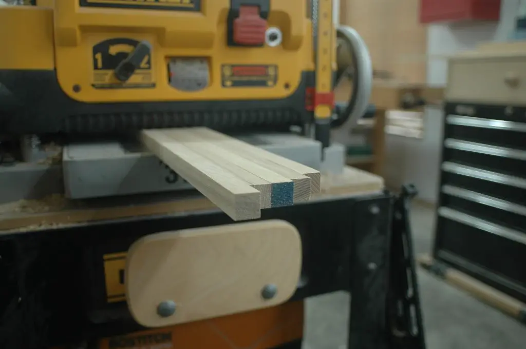 Wood planer processing wooden boards in workshop