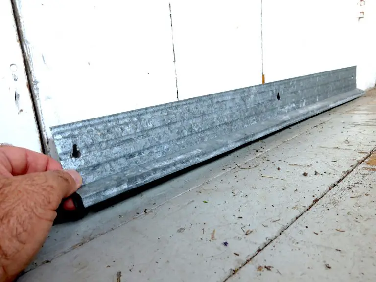 Person installing weather stripping on garage door