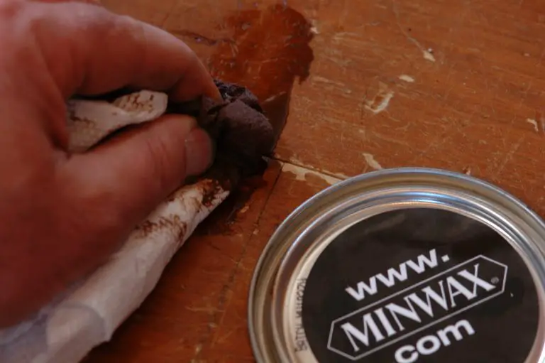 Hand applying wood finish with cloth.