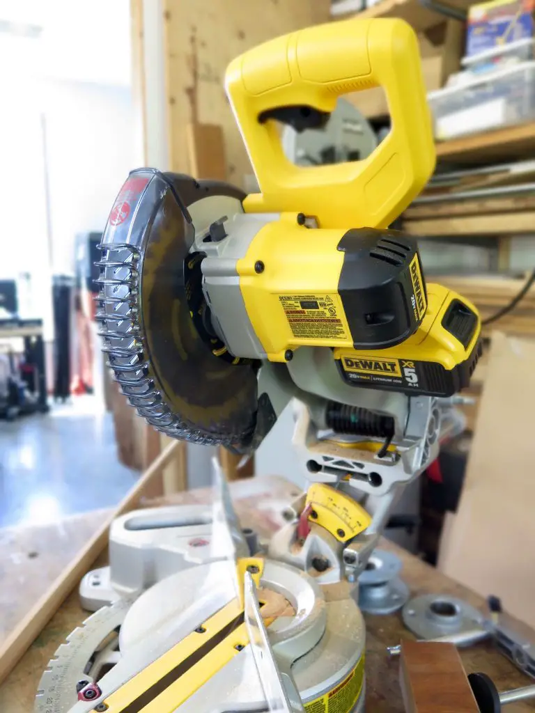 Yellow miter saw on workshop table