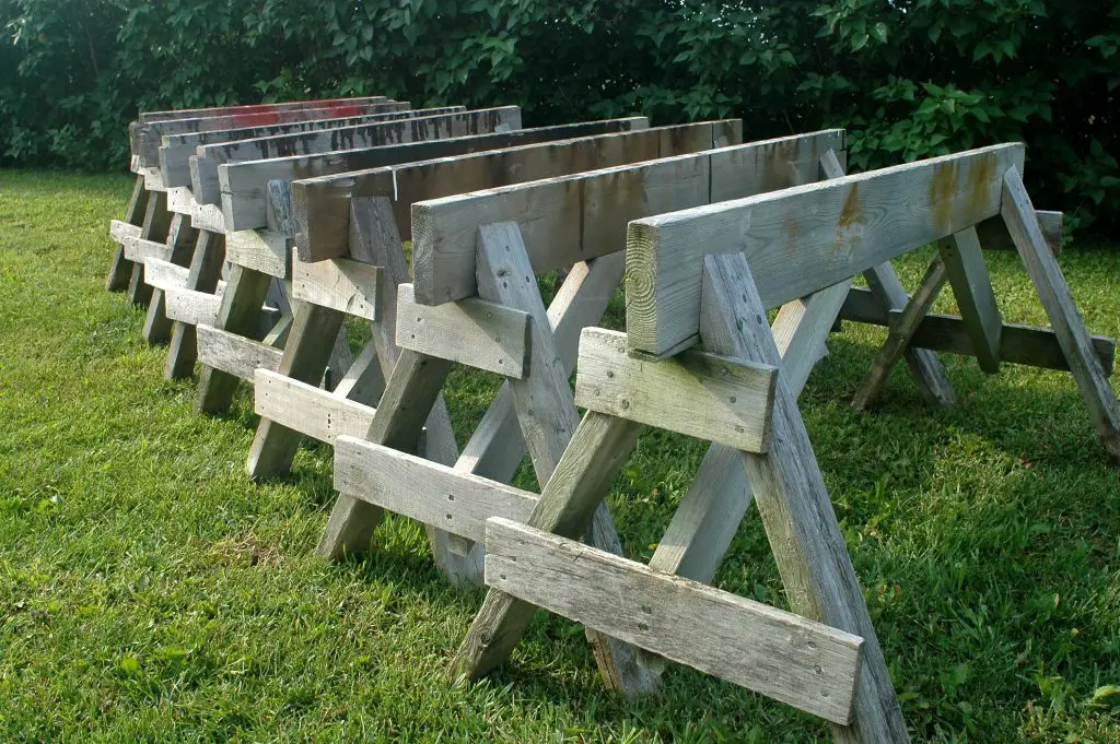 Row of wooden sawhorses on grass