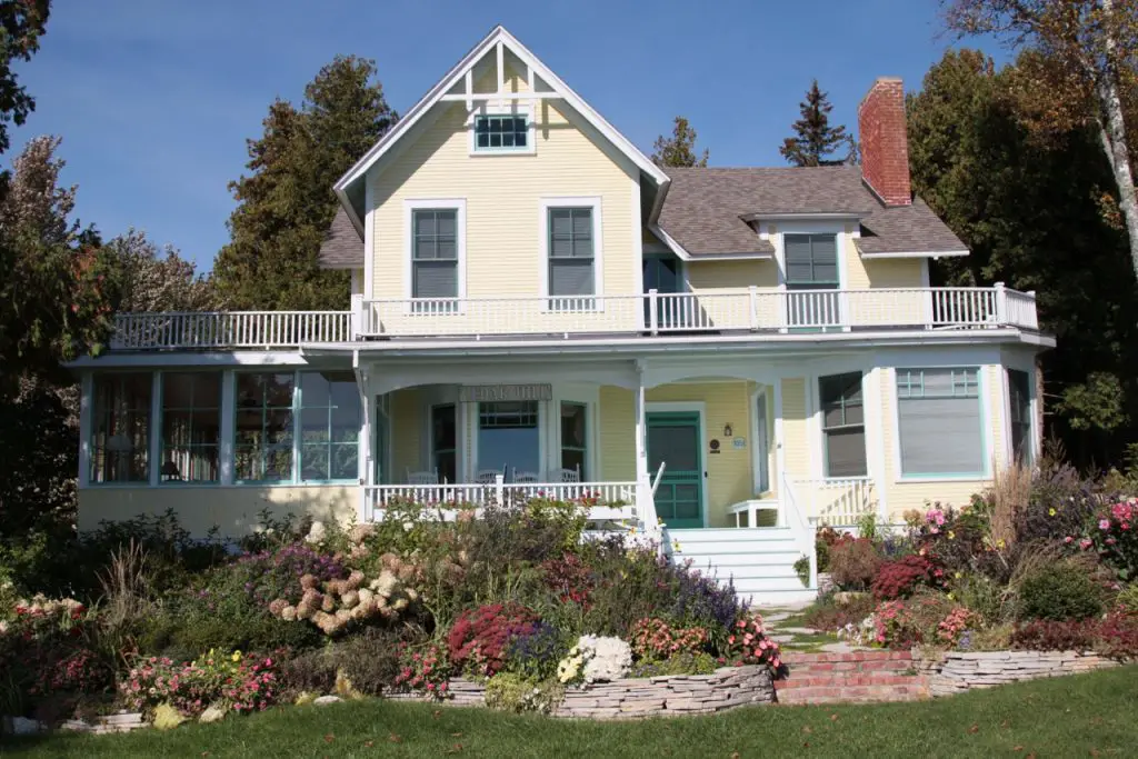 Yellow house surrounded by colourful garden
