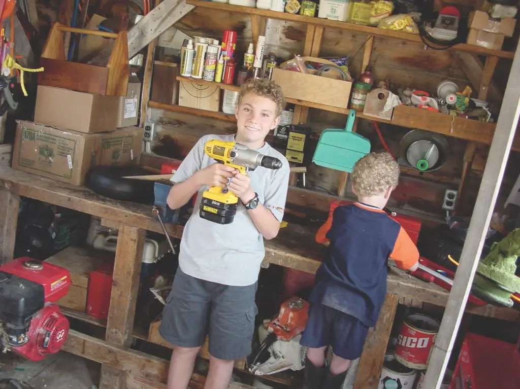 Kids in garage with tools and supplies.