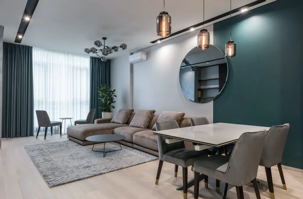 Contemporary living room with modern furniture, large mirror.