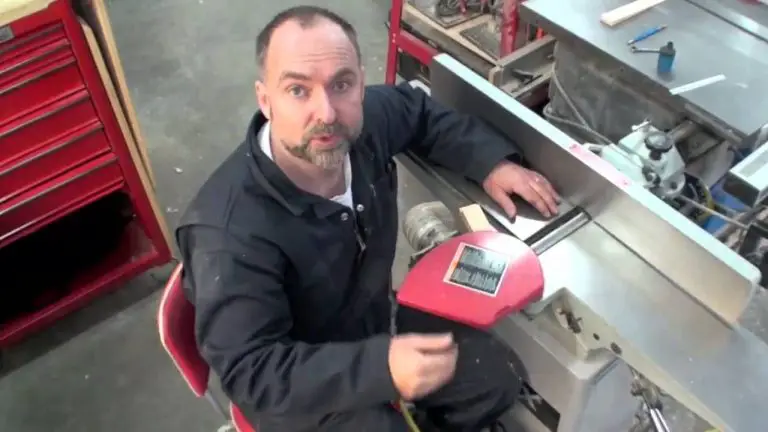 Man demonstrating equipment in workshop setting.