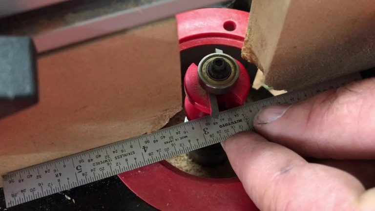Woodworker measuring with ruler and router bit