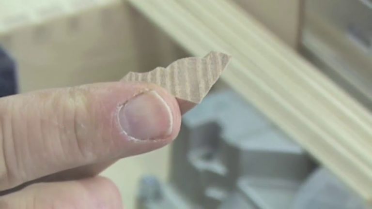 Close-up of hand holding cardboard piece.