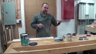 Man explaining wood staining techniques in workshop.