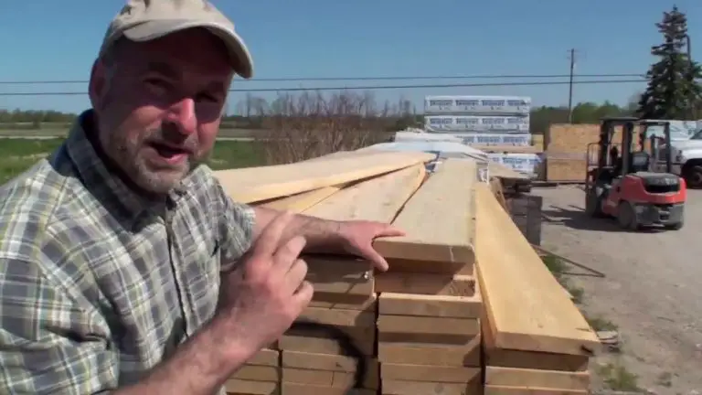Man beside stacked lumber at a sawmill