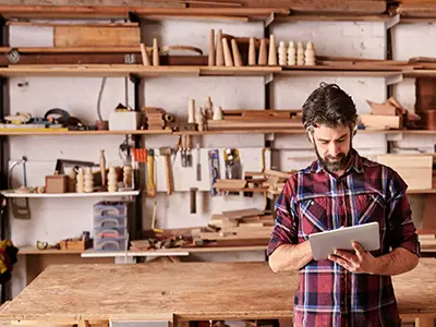 Man reading tablet in carpentry workshop
