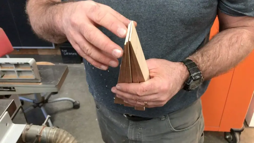 Person holding wooden geometric model in workshop