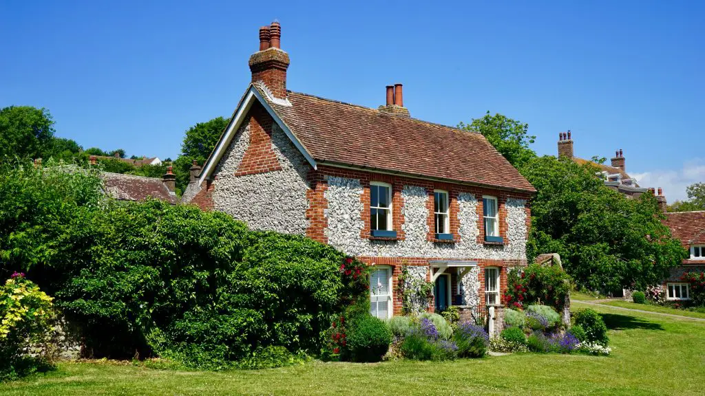Charming brick house with lush garden landscape.