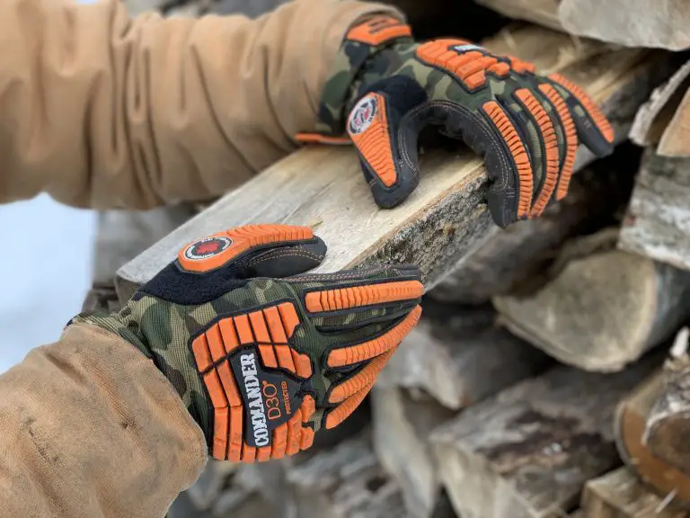 Person stacking wood while wearing protective gloves.