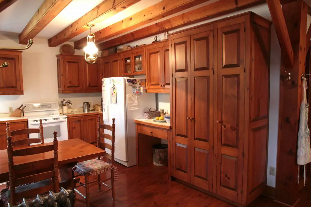 Rustic kitchen with wooden cabinets and dining area.