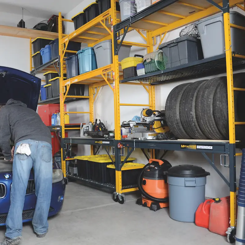 Organized garage with yellow storage shelves and car repair