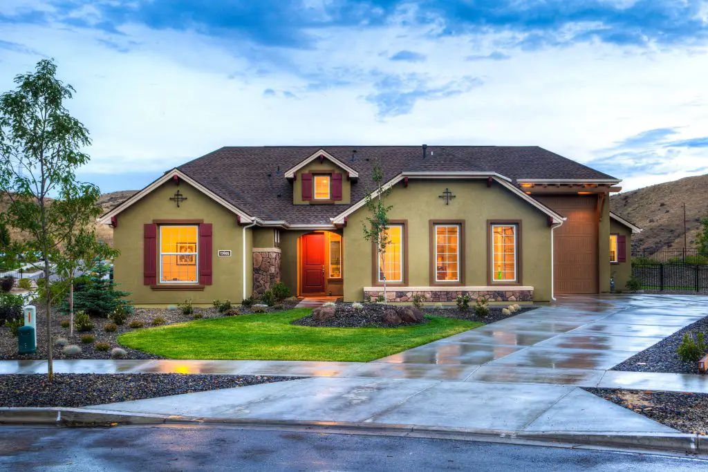 Modern suburban house with green lawn and driveway.