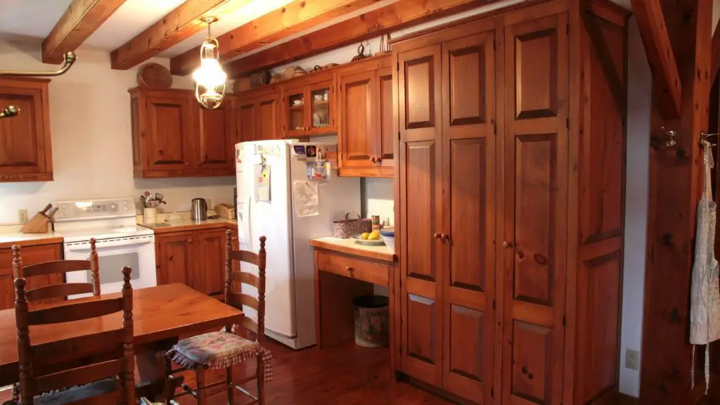 Rustic kitchen with wooden cabinets and dining table.