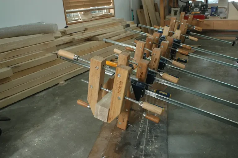 Wood clamps securing planks in workshop.