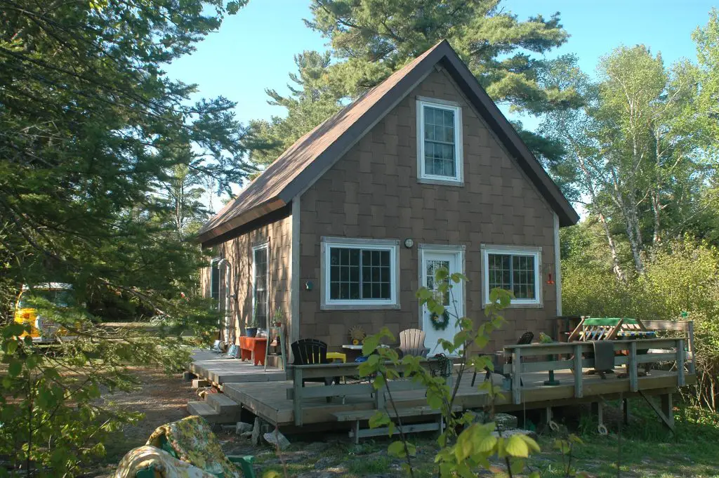 Rustic Canadian cabin surrounded by trees.