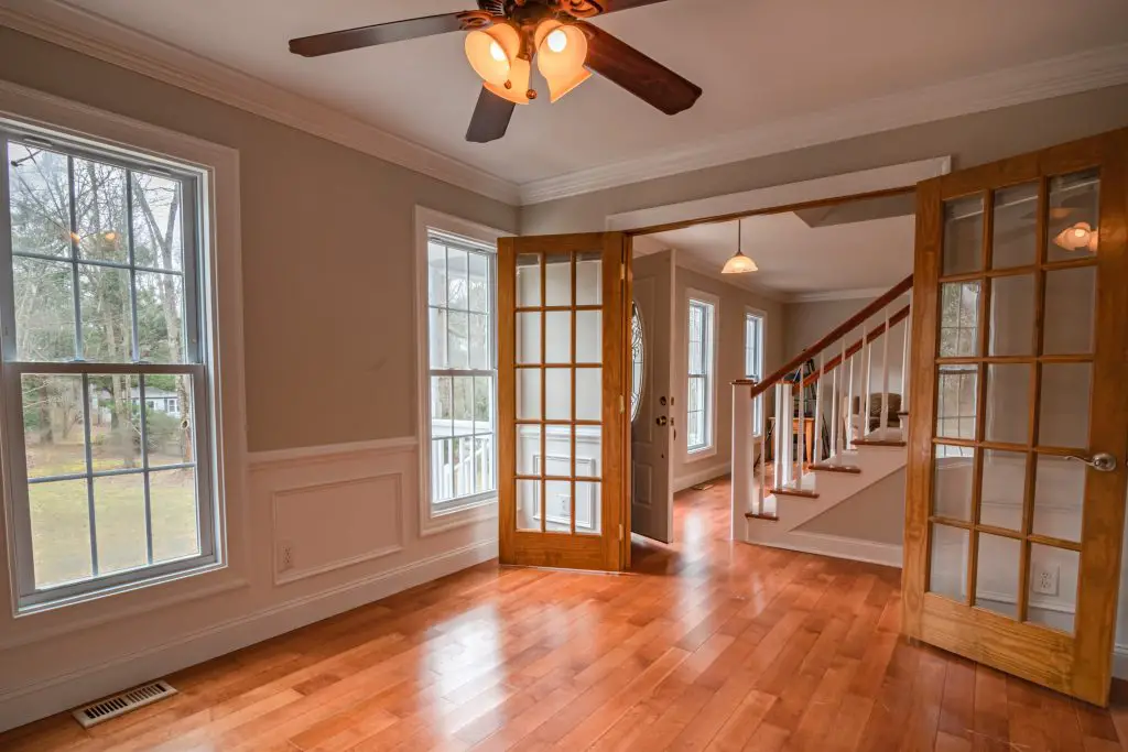 Bright room with wooden French doors and staircase.