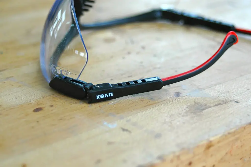 Uvex safety glasses on wooden table.